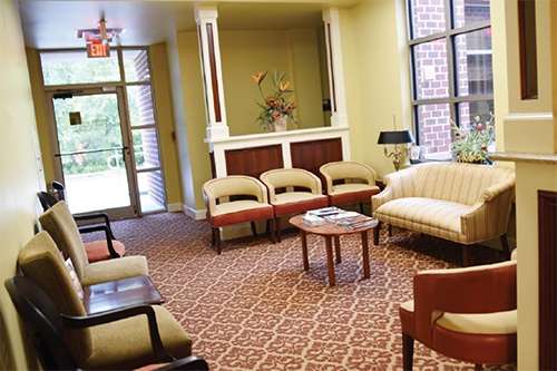Waiting room area with white couches and chairs