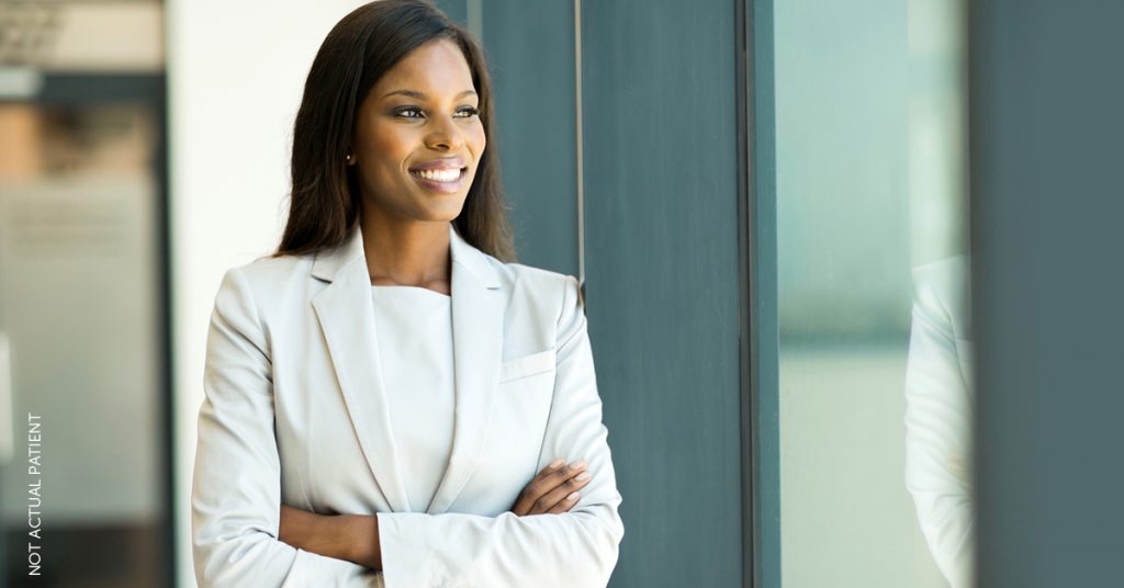 Woman in suit showing off her youthful appearance after having fillers