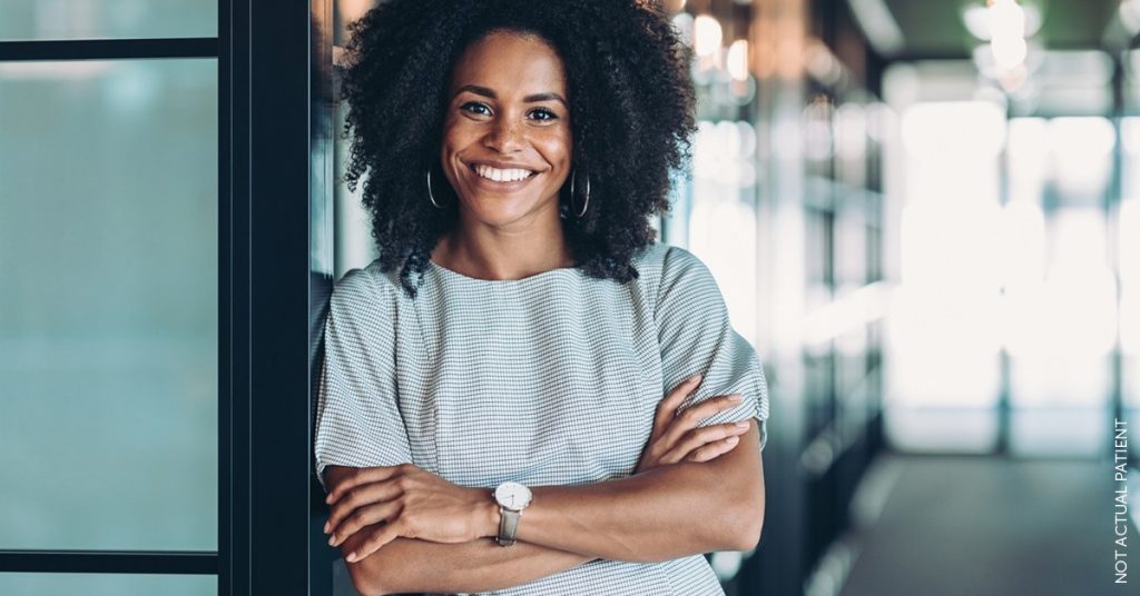 Confident woman standing against wall