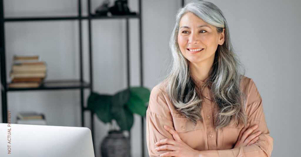 Mature woman smiling with her arms crossed (not actual patient)