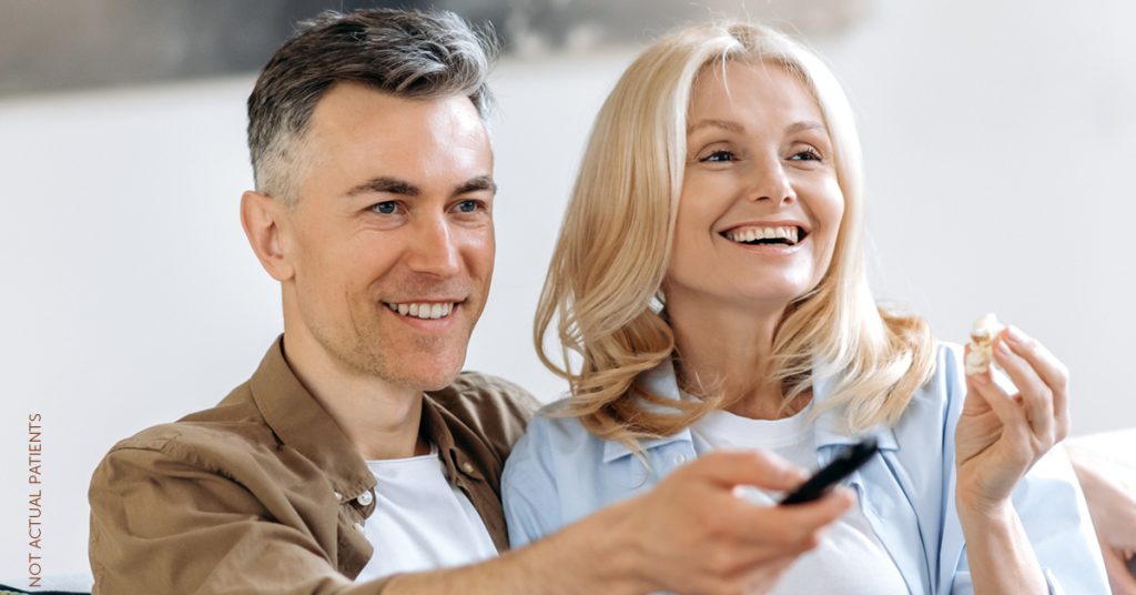 Couple sitting together watching TV (not actual patients)